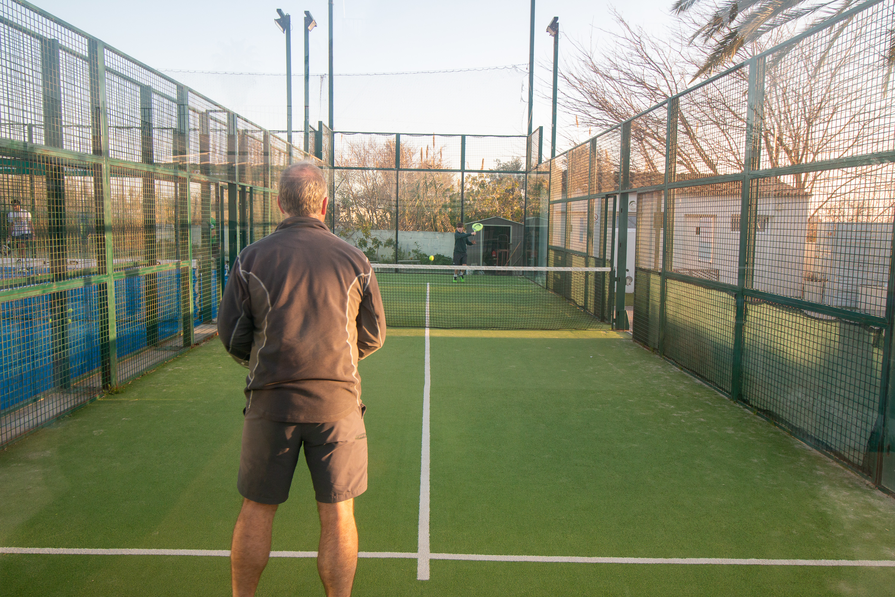 hombre y niño jugando en pista individual de padel